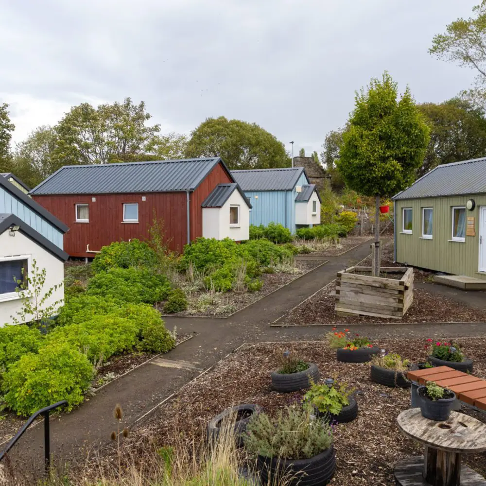 Small houses painted in different colours around a garden