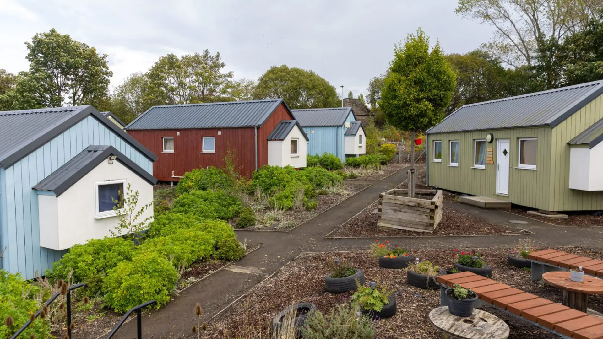 Small houses painted in different colours around a garden