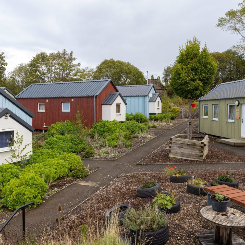 Small houses painted in different colours around a garden