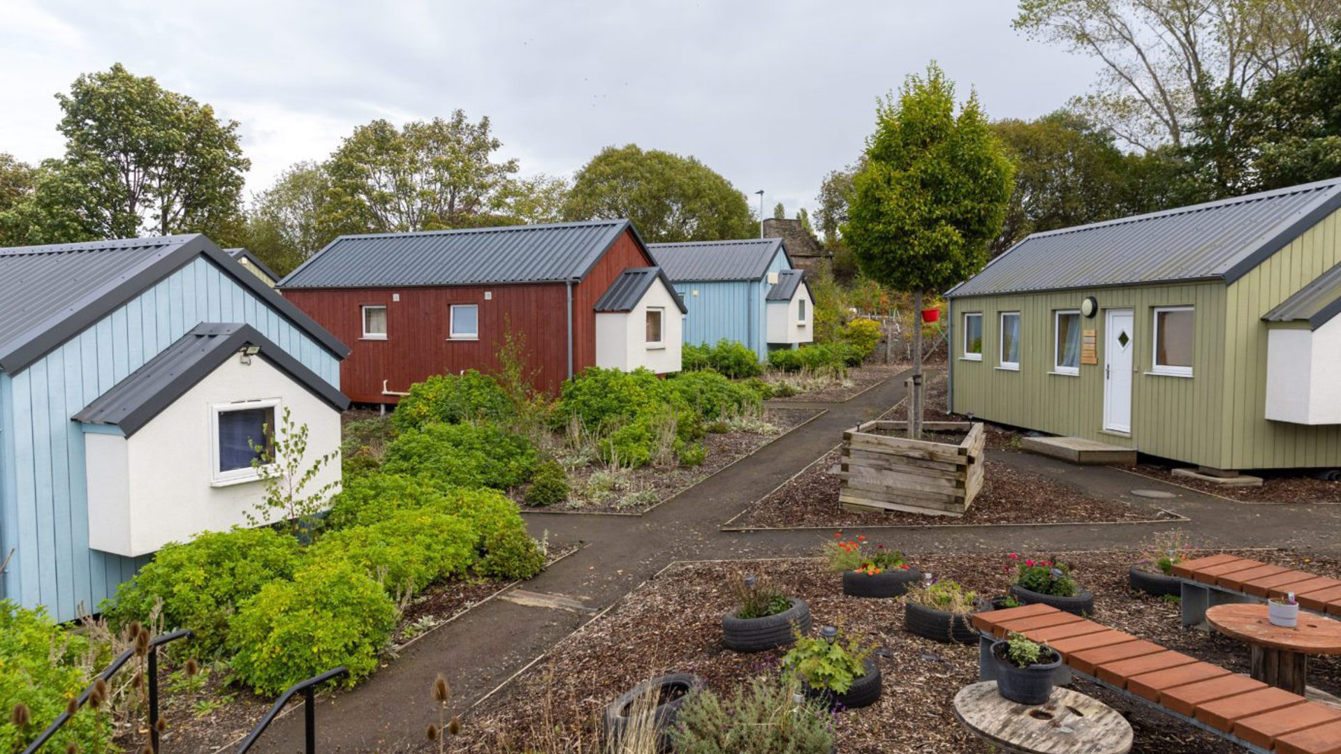 Small houses painted in different colours around a garden
